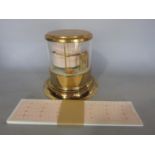 A small brass finished barograph with spare charts. 15cm base diam x 14cm high.