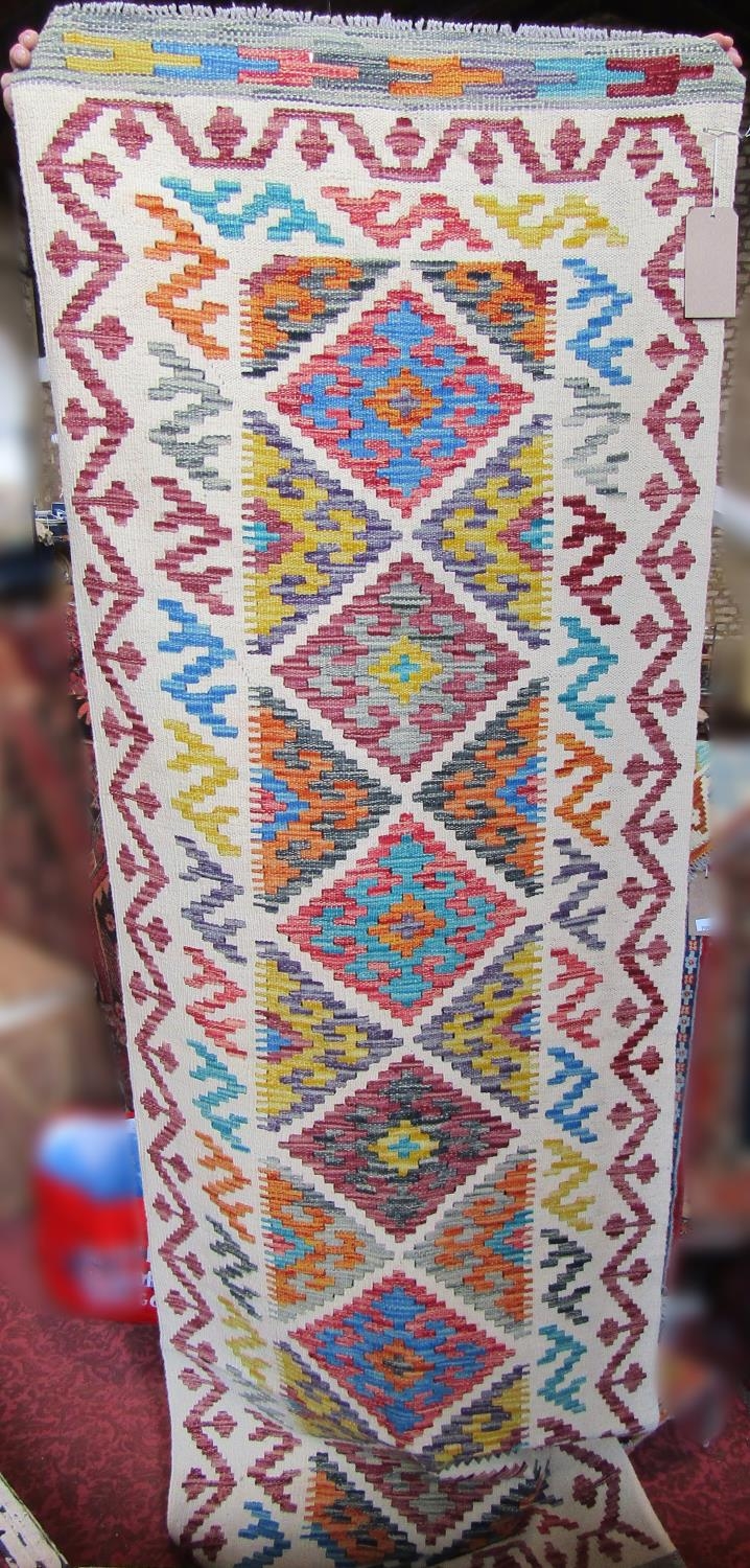 A Chobi Kilim runner in a pale colour way of stepped diamonds, 243cm x 79cm approx