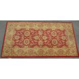 A Sarouk style runner with an overall gold floral design on a red ground, 160cm x 83cm approx.