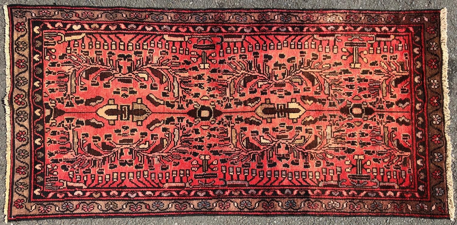A Hamadan rug with a floral pattern on a rose pink ground. 195cm x 95cm approx