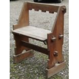 An ecclesiastical chair with wide seat within a pegged framed 82 cm wide