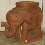 A vintage wicker novelty seat/stool in the form of a standing elephant with hand painted eyes