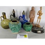 A miscellaneous collection of items including four coloured glass bottles, a carved wooden figure of