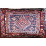 A kilim and carpet floor cushion, two kilim squab cushions with corduroy backs, a kilim saddle