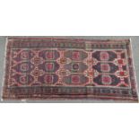 A Turkoman carpet with a geometric pattern on a predominantly brown ground, 183cm 88cm approx