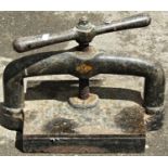 A small vintage cast iron book press with central screw thread and club shaped handle 40 cm (full