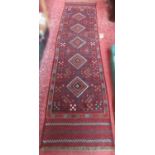 A Meshwani Runner with a multi coloured diamond repeating pattern, 249cm 60 approx.