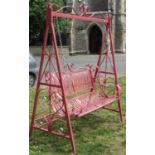 An iron work two seat garden swing with strapwork seat and back, chain hung and raised on A framed