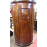 An unusual Victorian mahogany bow fronted hanging cupboard or hall robe, enclosed by a single full