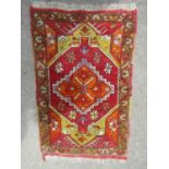 A small Middle Eastern mat with an orange central medallion 85cm x 55cm and another 105cm x 56 cm