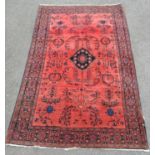 A very fine Persian rug with stylised floral designs on a rosy pink ground 195cm x 120cm