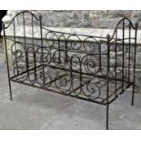A Victorian green painted cast iron single bedstead with tubular arched rails together with a