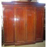 A Victorian mahogany breakfront wardrobe with fitted interior enclosed by four arched and panelled