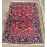 A Kashan carpet with overall floral red and blue pattern, 180cm x 130cm
