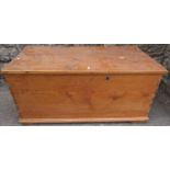 A 19th century stripped pine blanket box with hinged lid, drop iron work side carrying handles and