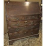 A Georgian style oak bureau for four long graduated drawers, the fall flap enclosing a fitted