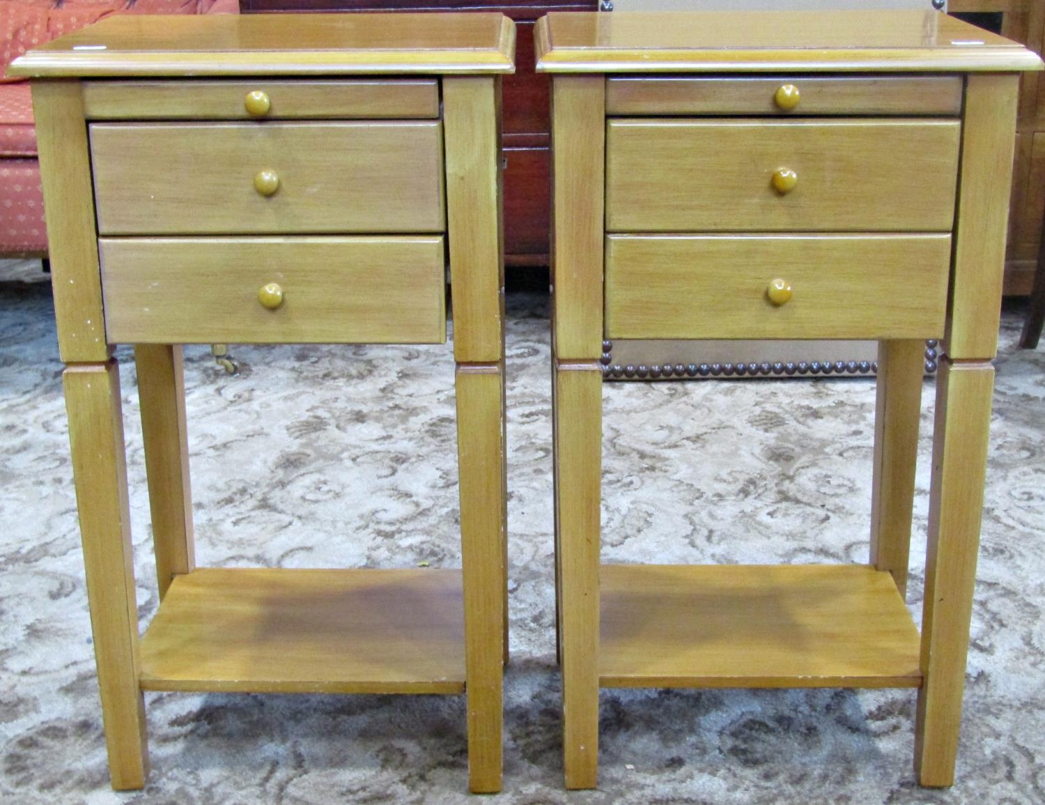 A pair of contemporary two drawer lamp tables with brushing slides, raised on square tapered