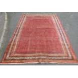 An old Afshar carpet with an overall field small botehs on a pink ground, 370cm x 260cm