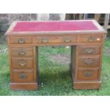 An Edwardian oak pedestal writing desk of nine drawers with inset leather top, 106 cm in width