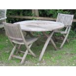 A weathered hardwood folding circular garden table with slatted top 125 cm diameter, retailed by