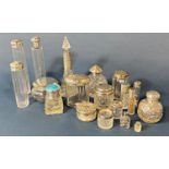 Eighteen glass scent/dressing table bottles, etc, all with silver necks or lids