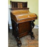 A Victorian walnut and figured walnut 'piano' davenport, the piano top raised on a pair of shaped