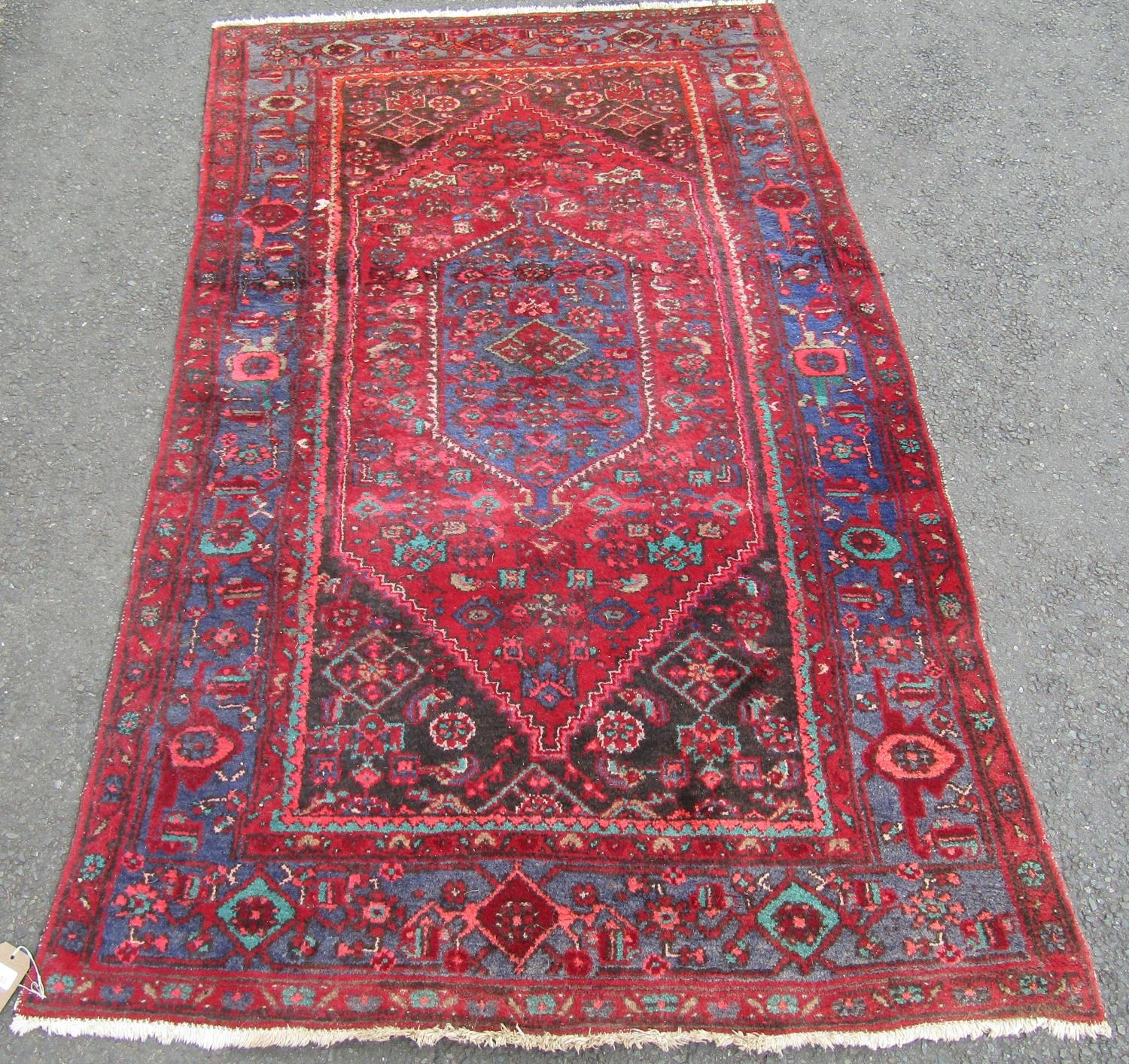 An old Middle Eastern rug with a central medallion and stylised floral pattern, 221cm x 131cm.