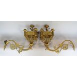 A pair of gilt finished wall mounted ecclesiastical candelabra each with five sconces, 46cm wide