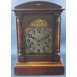 A late 19th century cottage mantle clock with polished softwood case, broken arch dial and applied