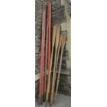 A collection of ashwood oars, some with natural finish, some with oxide paint finish, together