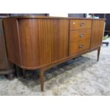 An Austinsuite teak sideboard, fitted with a tower of three central drawers, flanked by tambour