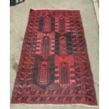 A mid 20th century predominantly red and black Middle Eastern carpet with a mirrored geometric