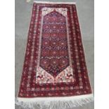 A mid 20th century Beloudj rug with a geometric central diamond shaped medallion with stylised