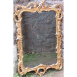 A gilded wall mirror in an 18th century style with floral and other detail, 122cm x 80cm