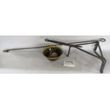 A wrought iron trivet stand, a rustic wooden bowl a loving spoon , antique cannon ball etc