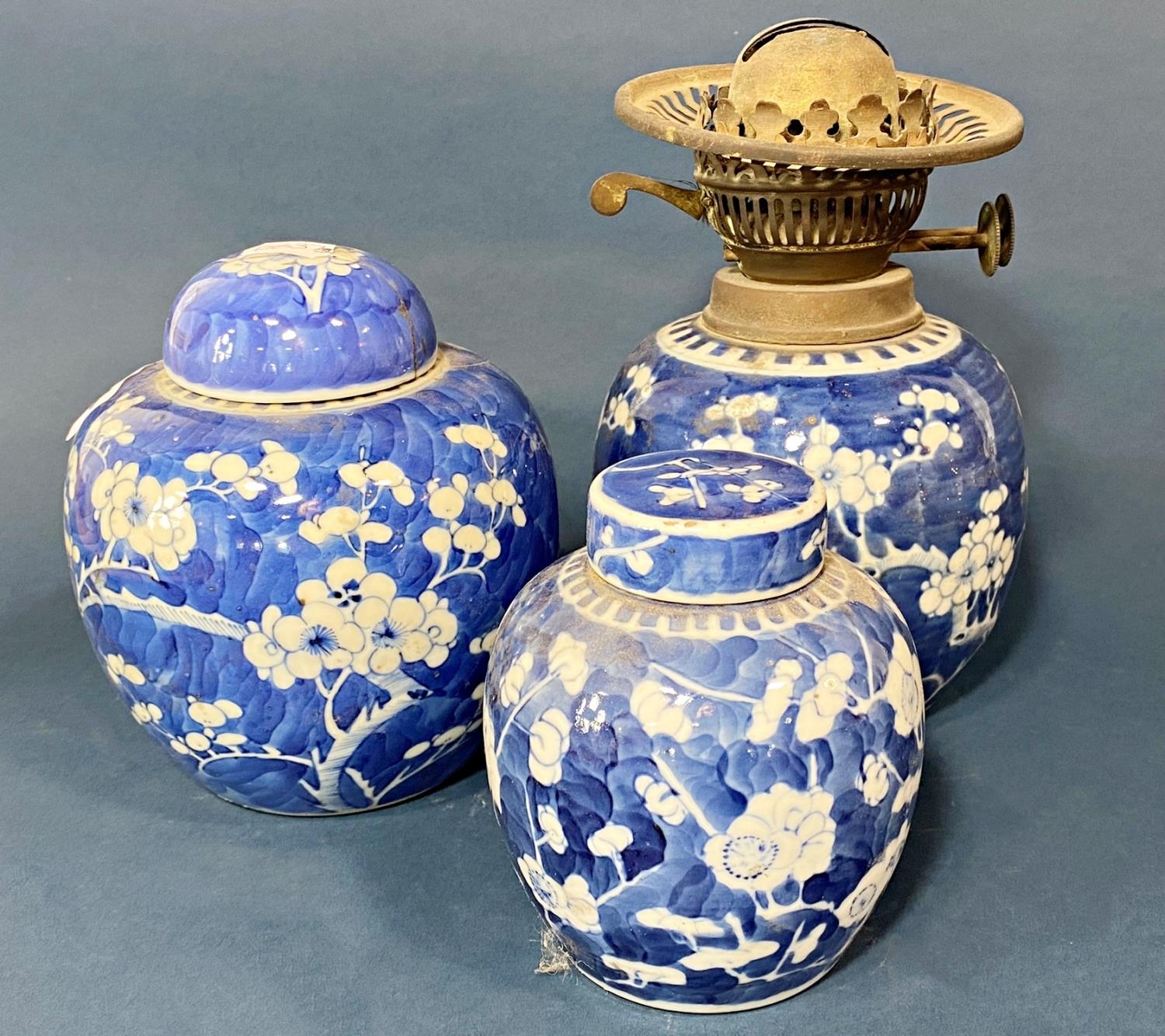 Three Chinese blue and white porcelain prunus jars with covers, one with oil lamp conversion, four-