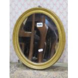 A simple Georgian oval gilt framed mirror with beaded border, 36 cm max