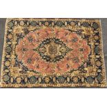 A Tabriz rug with a large central medallion surrounded by a floral pattern in hues of pink and blue,