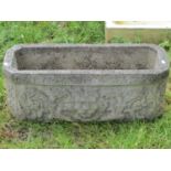 A weathered cast composition stone garden planter of rectangular form with canted corners, raised
