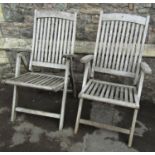 A pair of weathered hardwood folding garden armchairs with slatted seats and backs, labelled