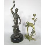 A Spelter figure of a blacksmith at work raised on a circular base, 44cm high, together with an