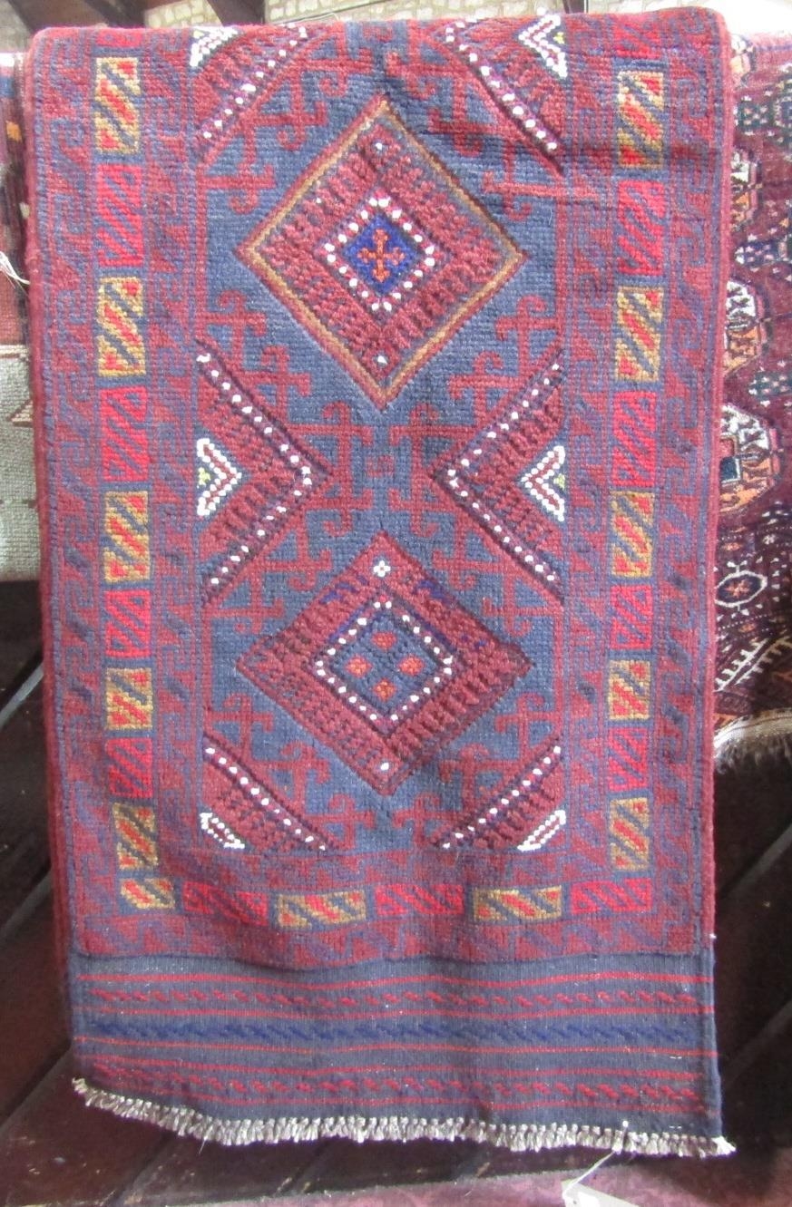A Meshwani runner with a central row of gul on a red and blue ground,254cm x 60cm.