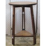 A small Arts & Crafts oak occasional table with circular top raised on three tapered pierced