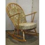 An Ercol rocking chair in a light colourway with stick back principally in beech with elm seat