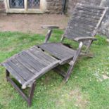 A weathered stained hardwood folding steamer type garden armchair with slatted, seat, back and