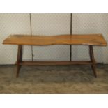 A rustic elm occasional table of rectangular form with boarded top, shaped outline and supports