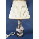 An oriental lamp base of high waisted form with all over blue, burnt orange and gilt floral