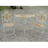 A weathered contemporary cream painted folding demi-lune garden table with lattice top and