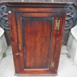Georgian fruitwood hanging corner cupboard with panelled door, brass H shaped hinges and Greek key