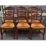 A set of six stained beechwood French provincial ladderback dining chairs with drop in rush seats
